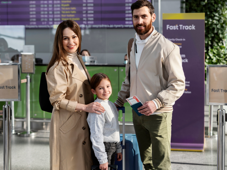 A family of three stands at the airport's Fast Track check-in area, holding travel documents.