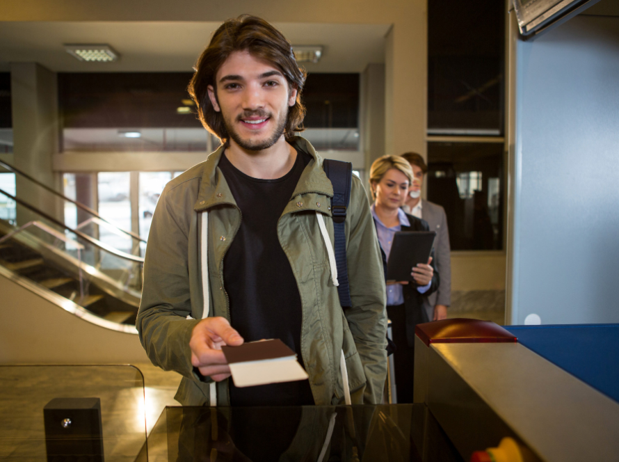 International student presenting documents at an airport immigration checkpoint for an F-1 visa entry process.